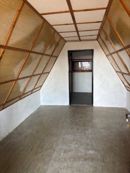 An attic room with wooden and white walls in recreational grounds.