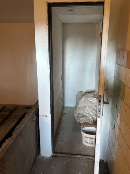 A narrow space with a metal bucket and construction material for recreational purposes and land.