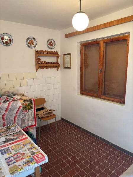 A kitchen with tiles, decorative plates, a wooden window, suitable for recreational purposes.