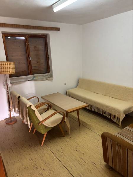A simple interior with retro furniture, a sofa, armchairs, and a wooden coffee table.