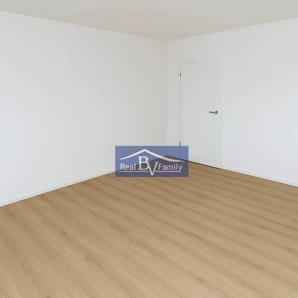 A spacious empty room with wooden flooring in a 2-room apartment.