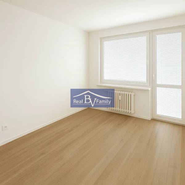 Bright room with wooden flooring and balcony doors in a 2-room apartment.