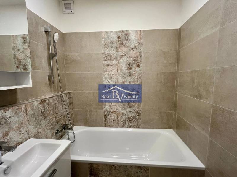 Bathroom with a bathtub and a shower head in a 2-room apartment.