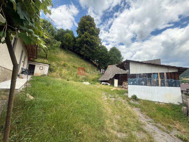 The yard of a rural family house in Záriečie on Záriečie with a grassy area and a shelter.