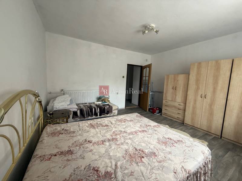 Bedroom in a family house with a large wardrobe and a double bed in light colors.