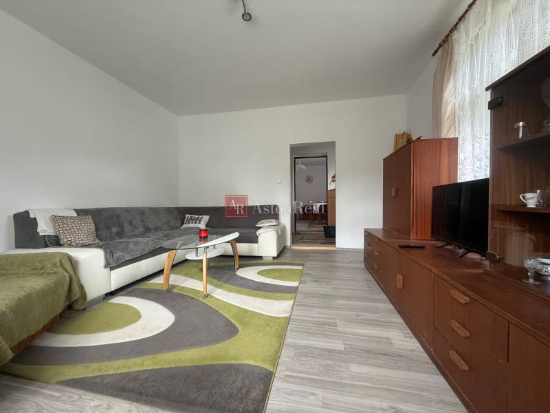 Living room in a family house with a comfortable sofa and a wooden wall unit.