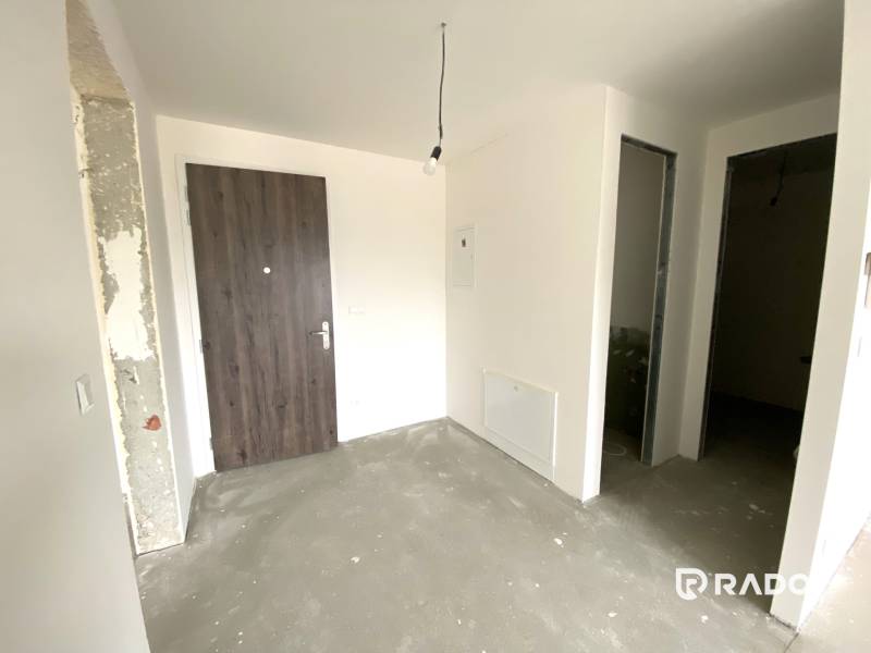 Entrance hall in a 2-room apartment with wooden doors and open spaces.
