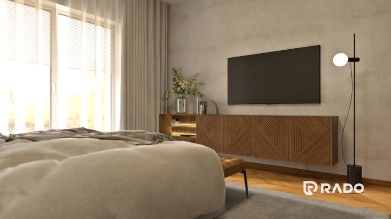 A bedroom in a 2-room apartment with a TV, a dresser, and decorative plants.