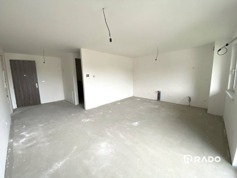 Spacious unfurnished living room and entrance door in a 2-room apartment.