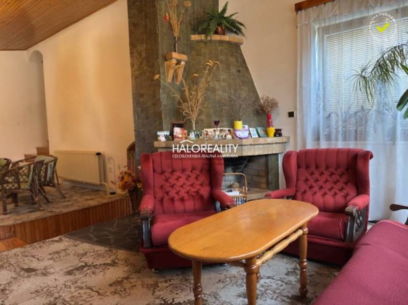 Living room in a family house with a fireplace and red armchairs.