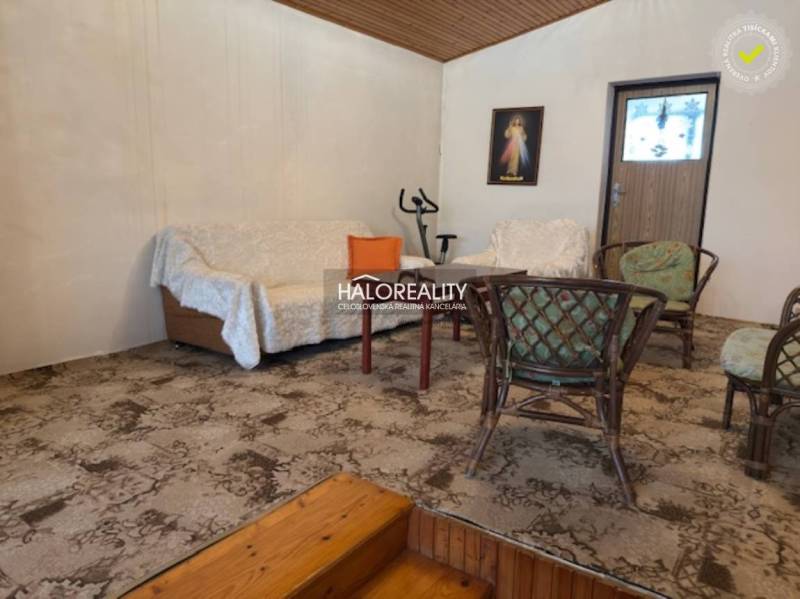 Living room in a family house with a sofa, chairs, and a carpet.