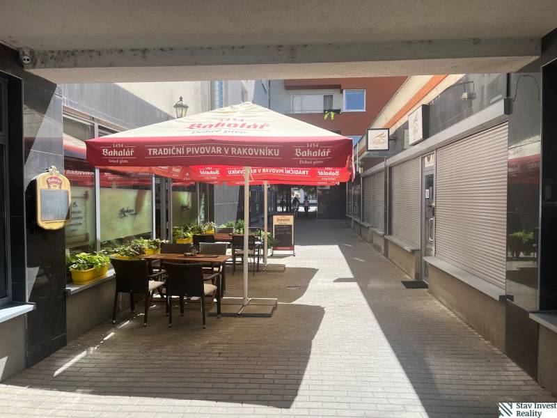 A café with tables and an umbrella on Lichnerova Street in Senec.