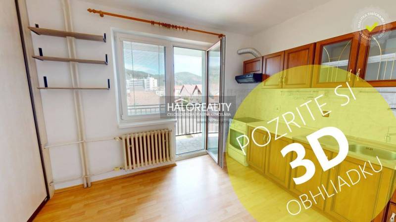 Studio apartment with a practical kitchen, wooden cabinets, and a large window to let in natural light.