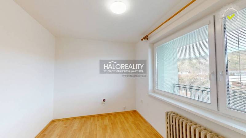 A room with a floating floor and a large window, ideal for a studio apartment, bright.