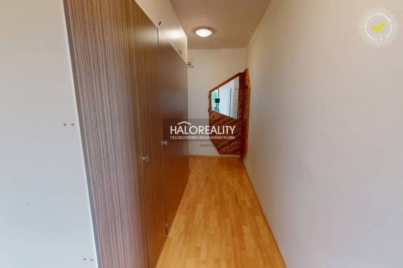 A narrow, bright space with wooden flooring, a built-in wardrobe, and a mirror, ideal for a studio apartment.