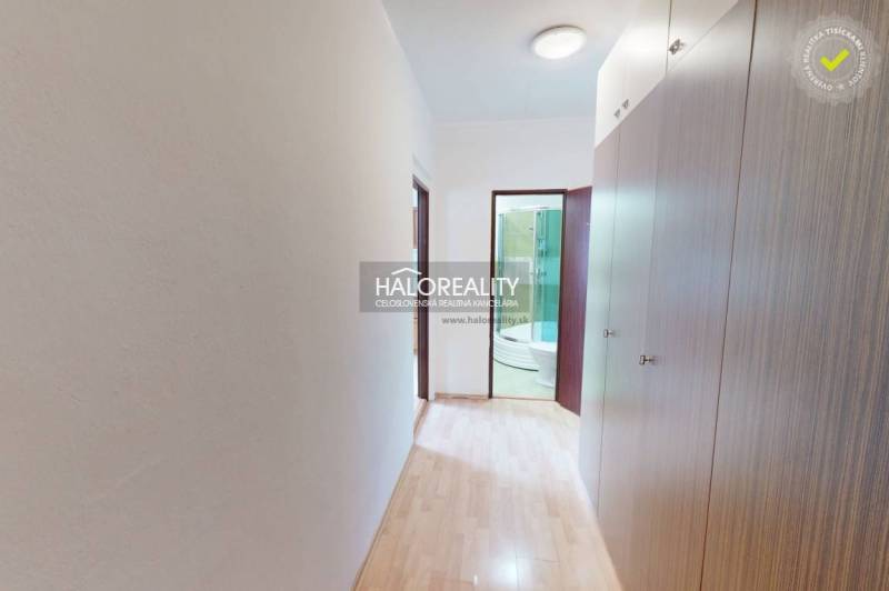 A hallway with a built-in wardrobe leading to the bathroom, ideal for a studio apartment.
