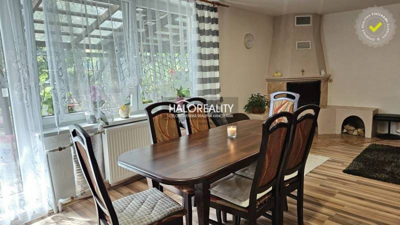 Dining area in a family house with a fireplace and large windows with a view.