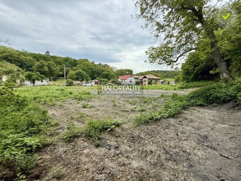 Land for housing in Selce with adjacent greenery and a view of houses in the background.