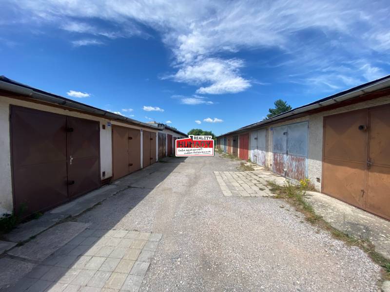 Row garages on Kolárska Street in Spišská Nová Ves on a sunny day.