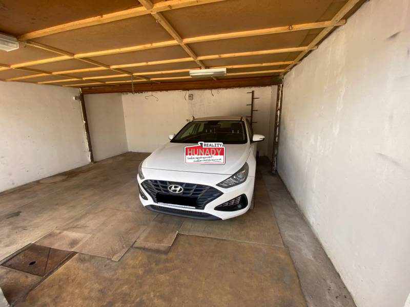The interior of a garage with a white Hyundai car parked inside.