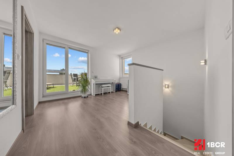 A bright hallway with a staircase and access to the terrace in a 4-room apartment.