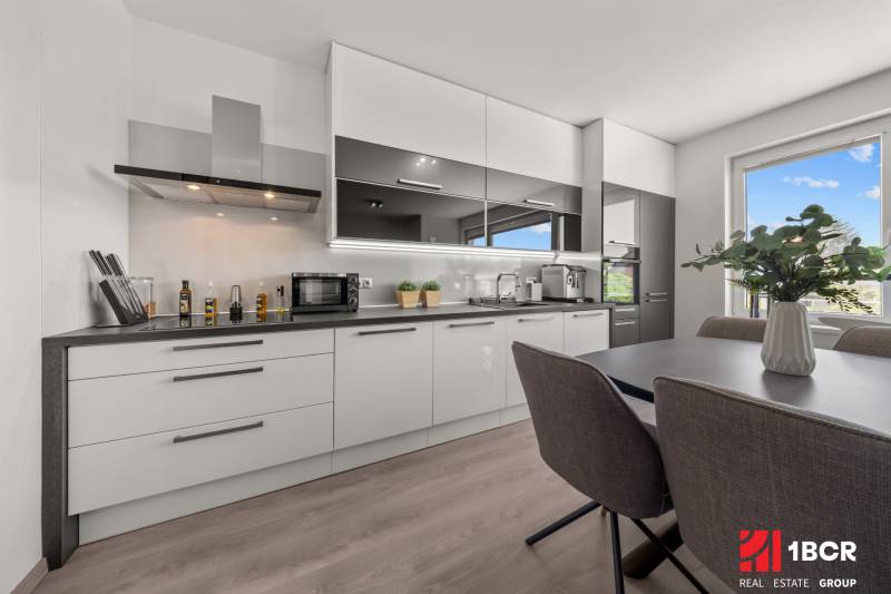 Kitchen in a 4-room apartment with a dining table and modern equipment.