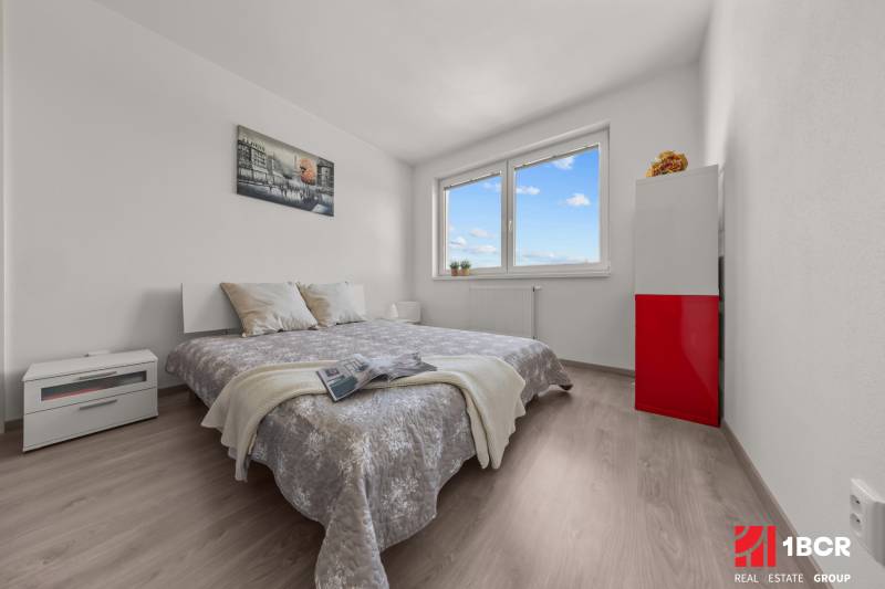 Bedroom in a 4-room apartment with a comfortable bed, white furniture, and modern decor.