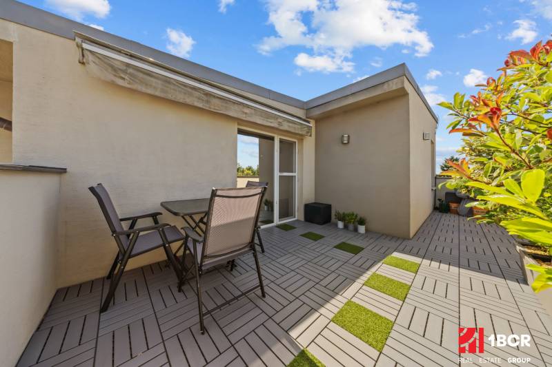 Terrace with seating in a 4-room apartment with greenery and an awning on Záhradná Street.