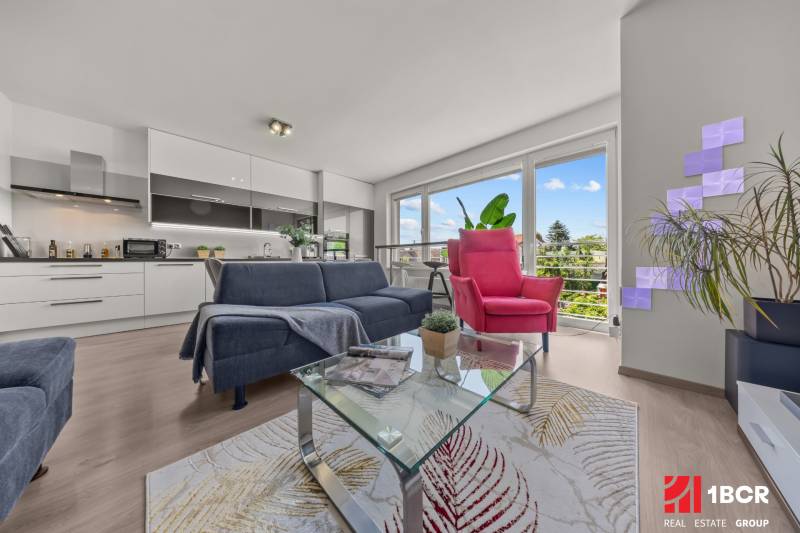 Living room with a sofa and an armchair in a 4-room apartment. Large windows with a view.