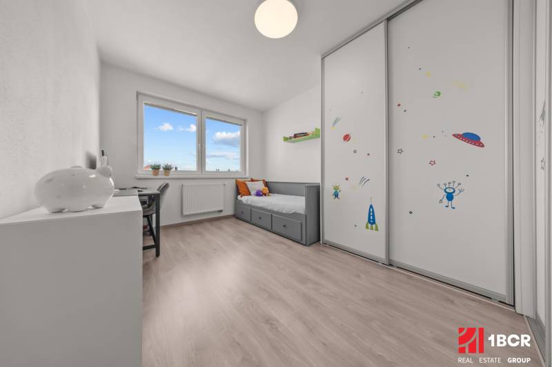 Children's room in a 4-room apartment with a bed, desk, and cabinet with space motifs.
