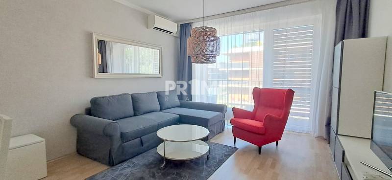 A stylish living room with a comfortable sofa and a red armchair in a two-room apartment.