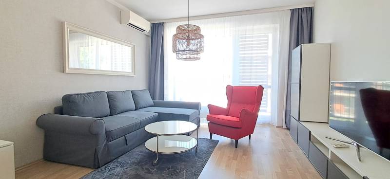 Living room with a comfortable sofa, a red armchair, and a television in a two-room apartment.