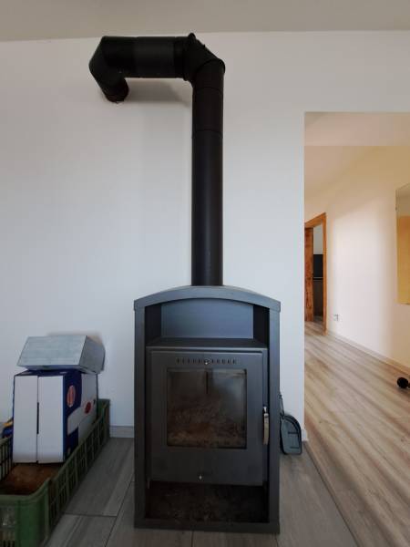 Wood-burning stove in a family house, minimalist design in a light interior.
