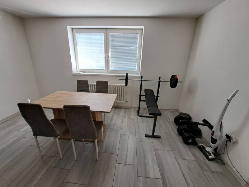 Dining room in a family house with fitness elements and a table with chairs.