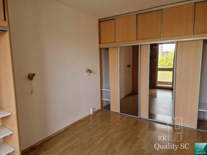 A spacious room with a built-in wardrobe in a 4-room apartment, with wooden flooring.