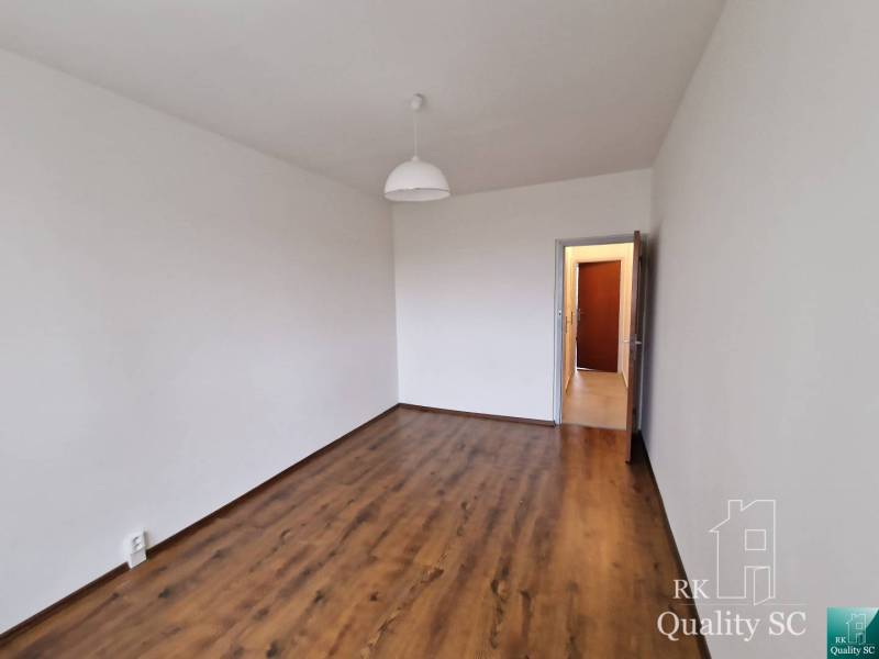 A room with a light wooden floor decor in a 4-room apartment, white walls.