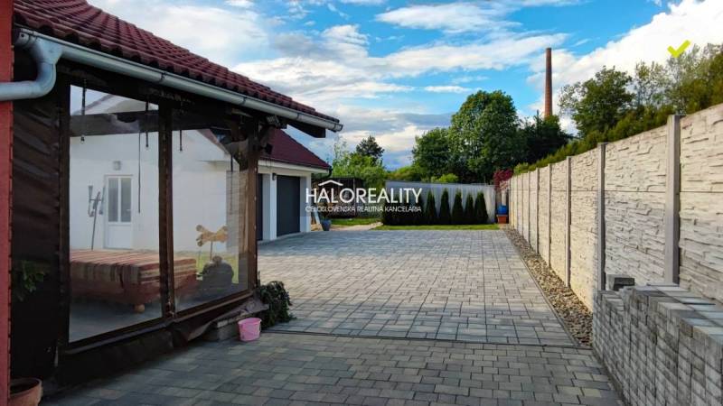A family house in Kalinovo with a paved courtyard, terrace, and fencing.