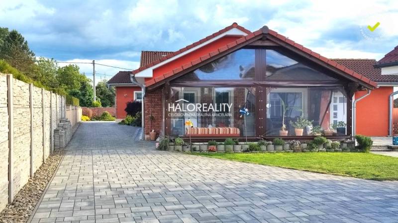 A family house in Kalinovo with a paved driveway and a glassed-in veranda.