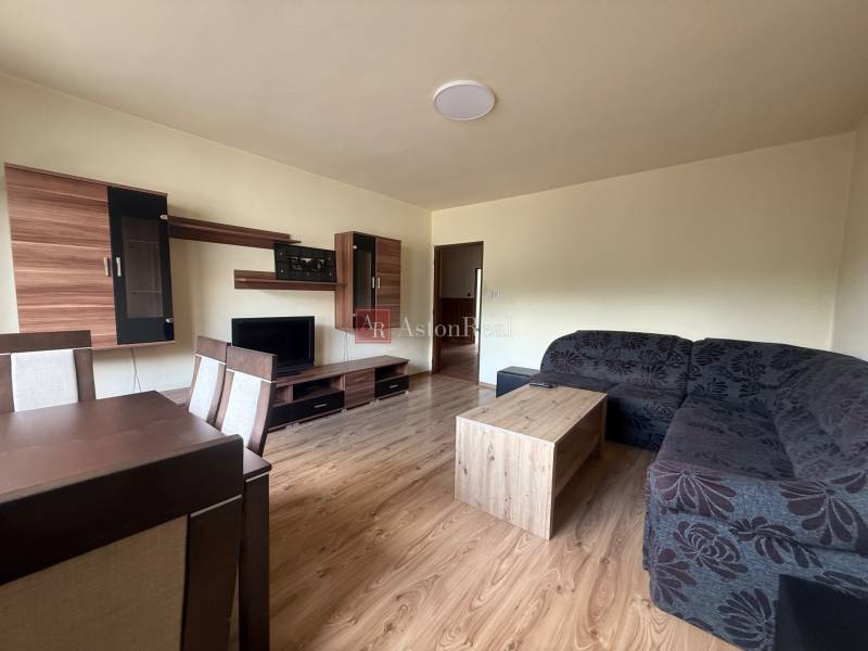 Living room in a family house with wooden furniture, a sofa, and a television.