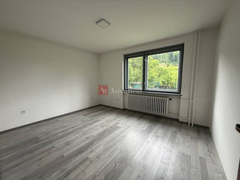 An empty room in a family house with a large window, light wooden floor.