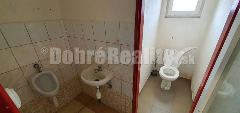 A restroom with a sink and a urinal in commercial premises.