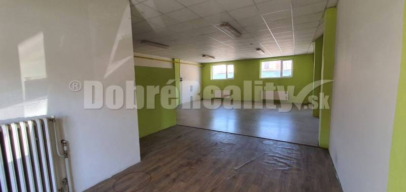 Interior of commercial premises with windows, flooring, and radiators.