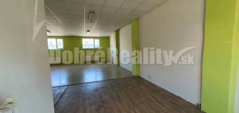 Interior of commercial spaces with wooden flooring and green walls, ready for rent.