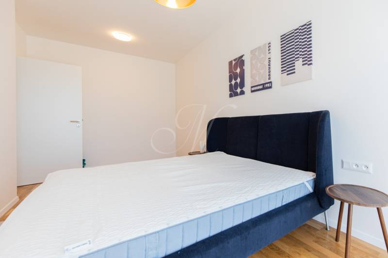 Bedroom with a bed and a nightstand in a 3-room apartment.