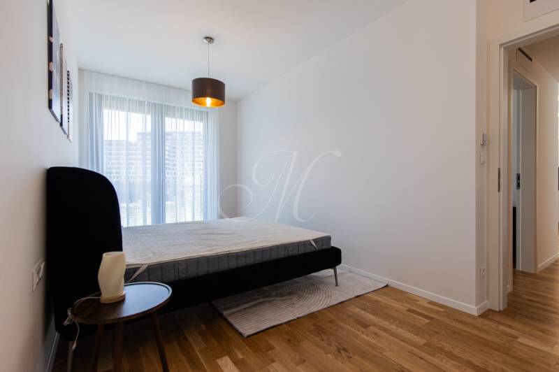 Bedroom with a gray bed and a window in a 3-room apartment.