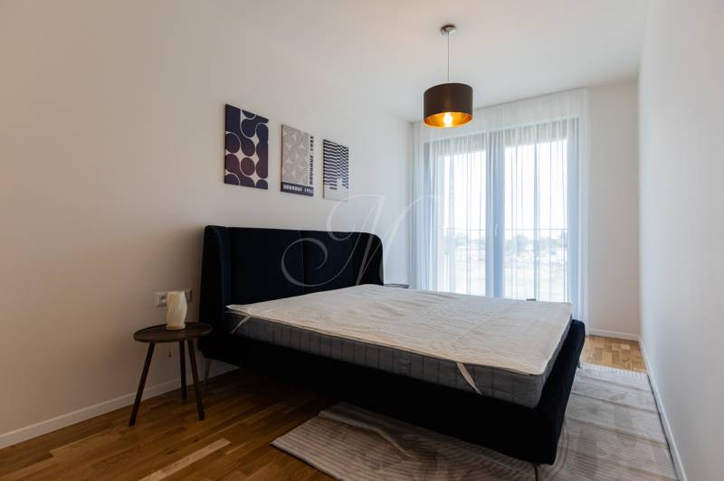 Bedroom with a bed and a nightstand, complemented by wall decorations.