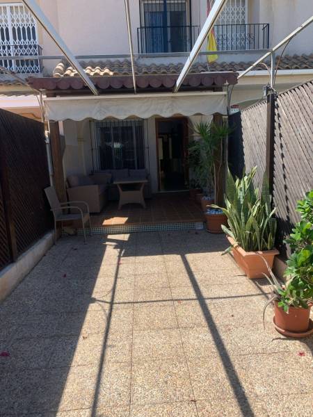 Terrace of a family house in Santiago de la Ribera with seating and greenery.