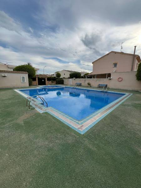 In Santiago de la Ribera, a courtyard of a family house with a swimming pool and benches is visible.