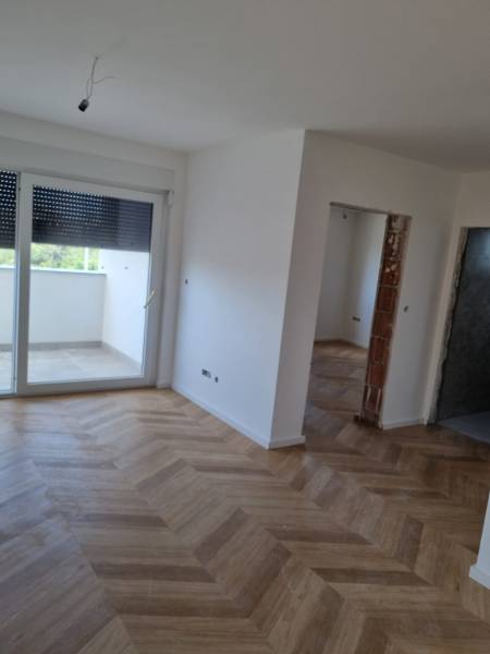 Interior of a 4-room apartment with wooden flooring and large windows.