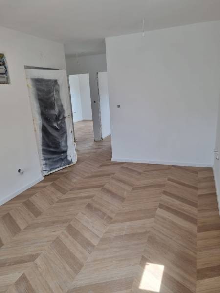 Unfinished space in a 4-room apartment with laid wooden flooring.